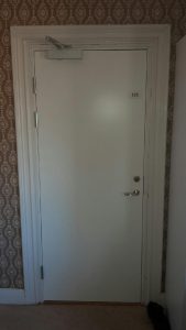 Dorma TS 83 dörrstängare samt lås monterad på dörr
