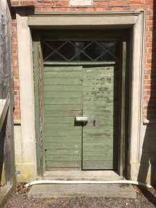 Låskåpa på grön äldre dörr